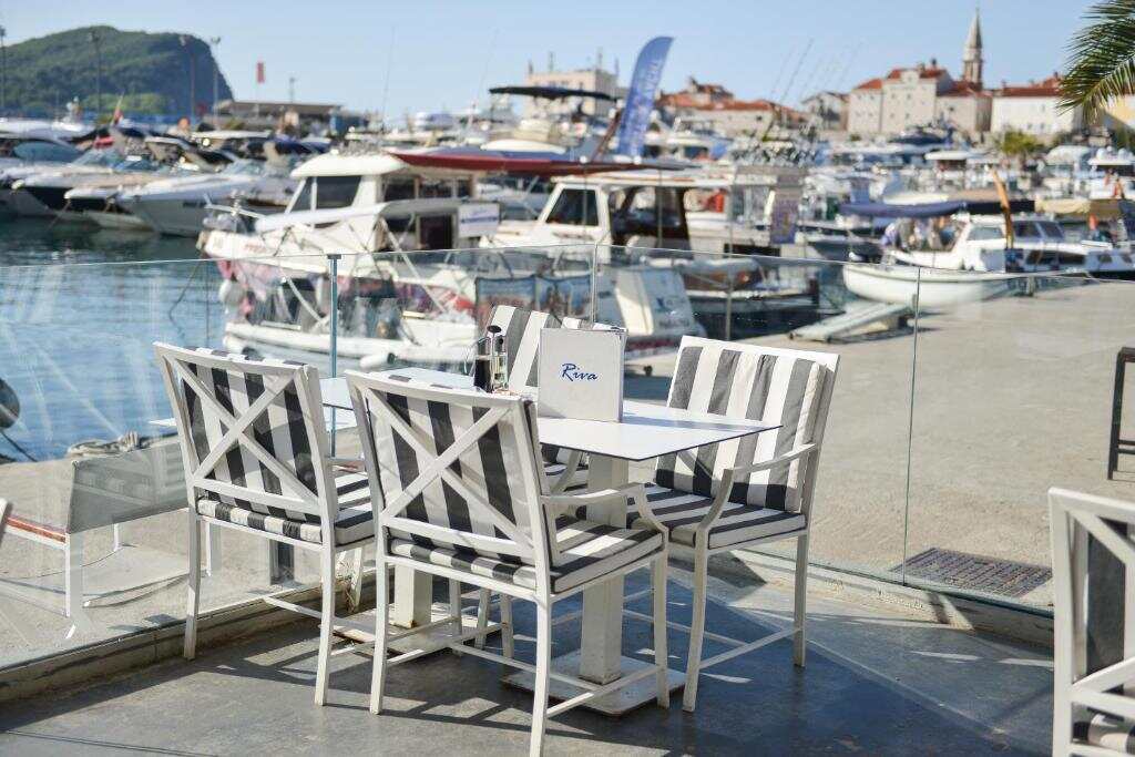 Table by the water at Hotel Riva with Budva marina behind